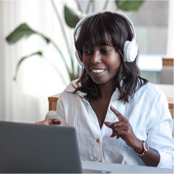 Ina De Becker in een online meeting bij laptop en met koptelefoon