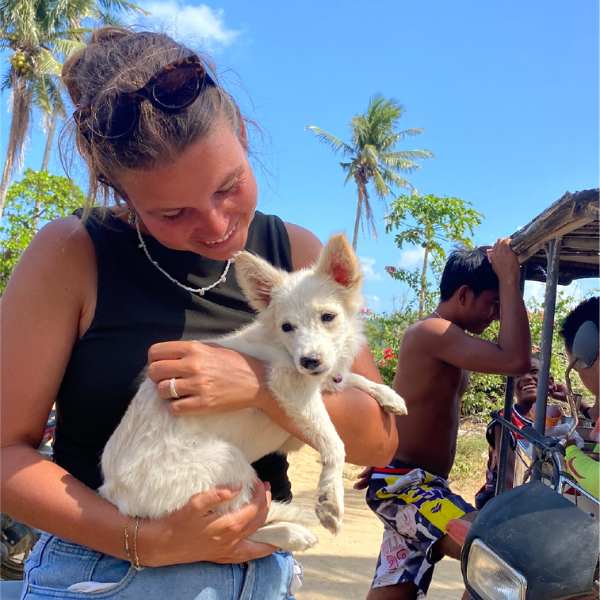 Manon in de Filipijnen met een witte hond